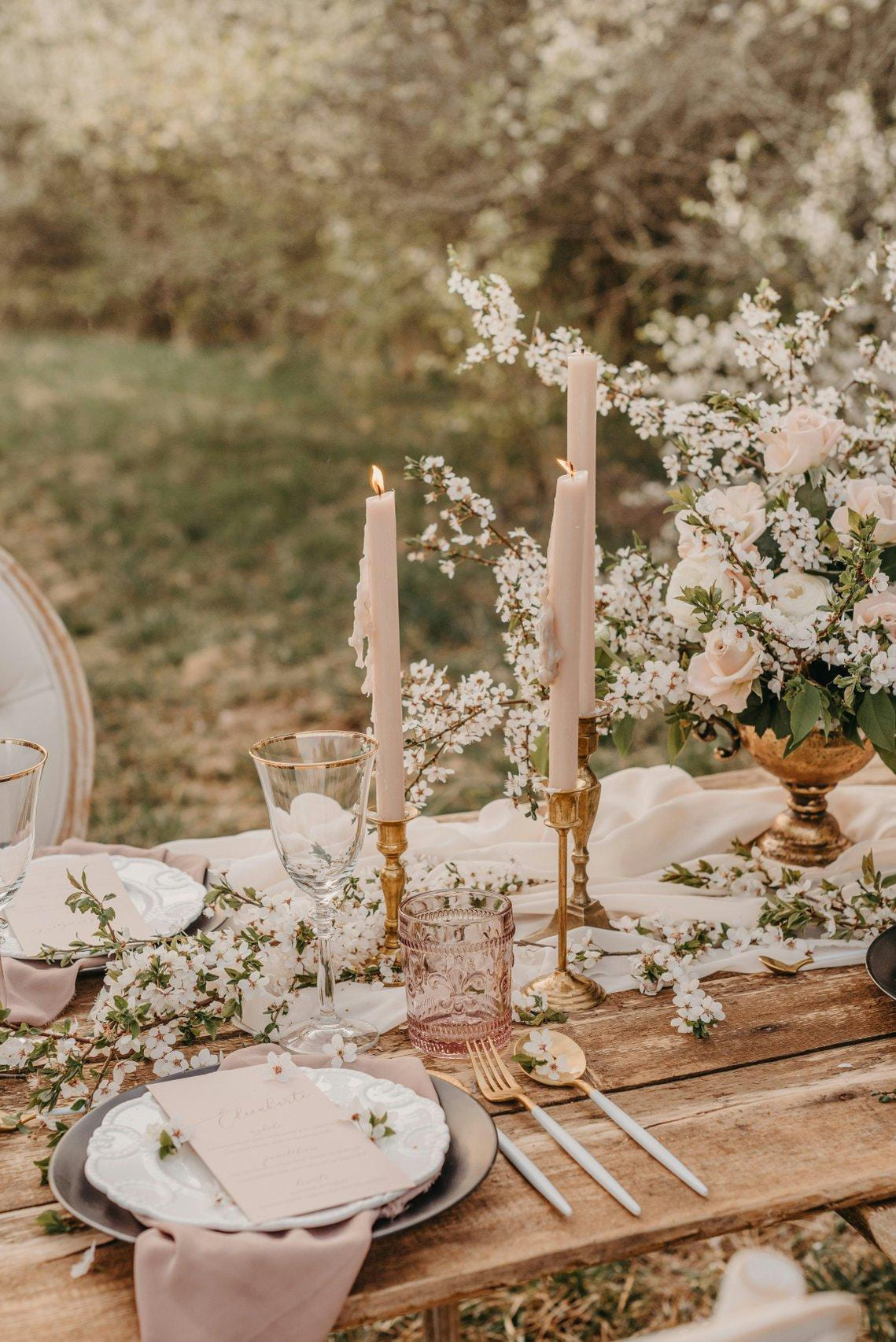 Table de mariage en plein air avec bougies et fleurs blanches