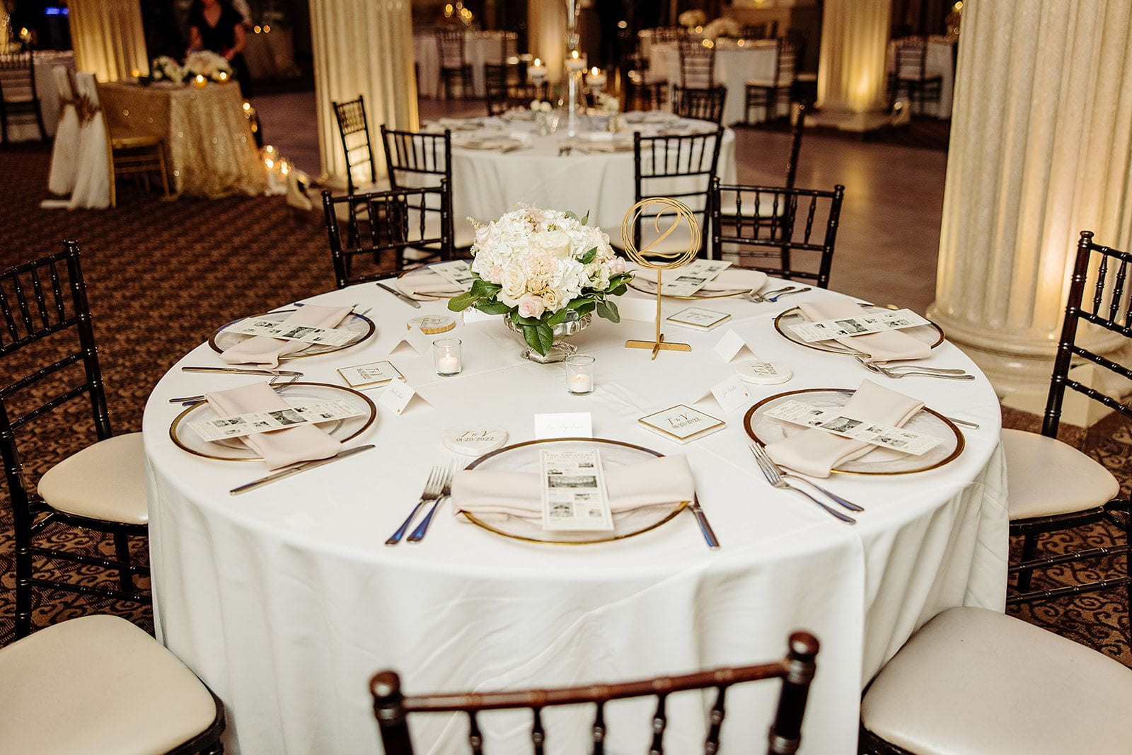 Table de réception ronde avec fleurs blanches et numéro de table doré